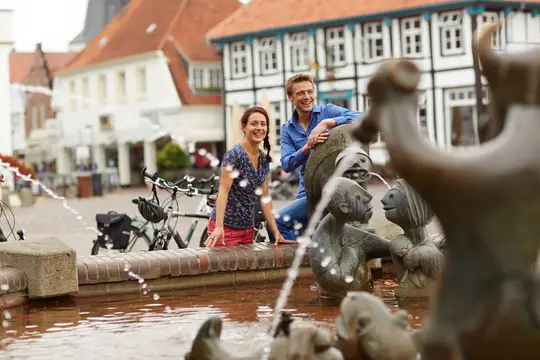 Urlauber am Fabeltier-Brunnen auf dem Marktplatz Lingen