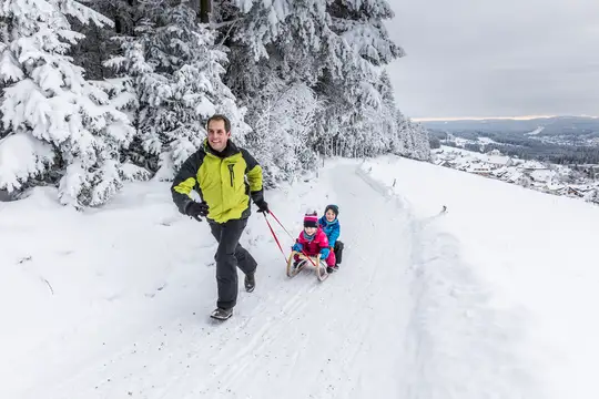 Familie beim Rodelspaß