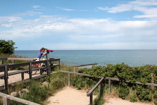 Radlerin am Ostseestrand mit Blink in die Ferne