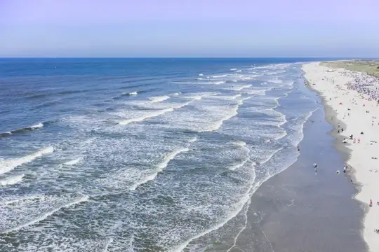 Luftbild von Norderney - Meer mit Gischt auf Strand zulaufend