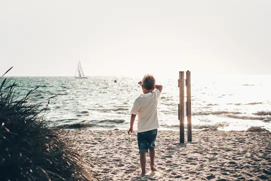 Strand mit Blick auf Segelboot