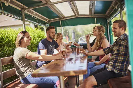 Bei einer Traktor-Planwagenfahrt wird Weinwissen auf unterhaltsame Artvermittelt.