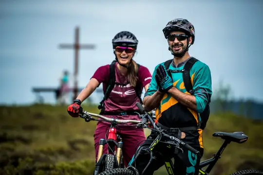 Biker unterwegs in der Bike-Arena Sauerland, ein Zwischenstopp beim Gipfelkreuz